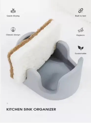 Gray silicone Diatom Mud sponge rack kitchen sink organizer with a curved cradle holding a white sponge with brown fringe.