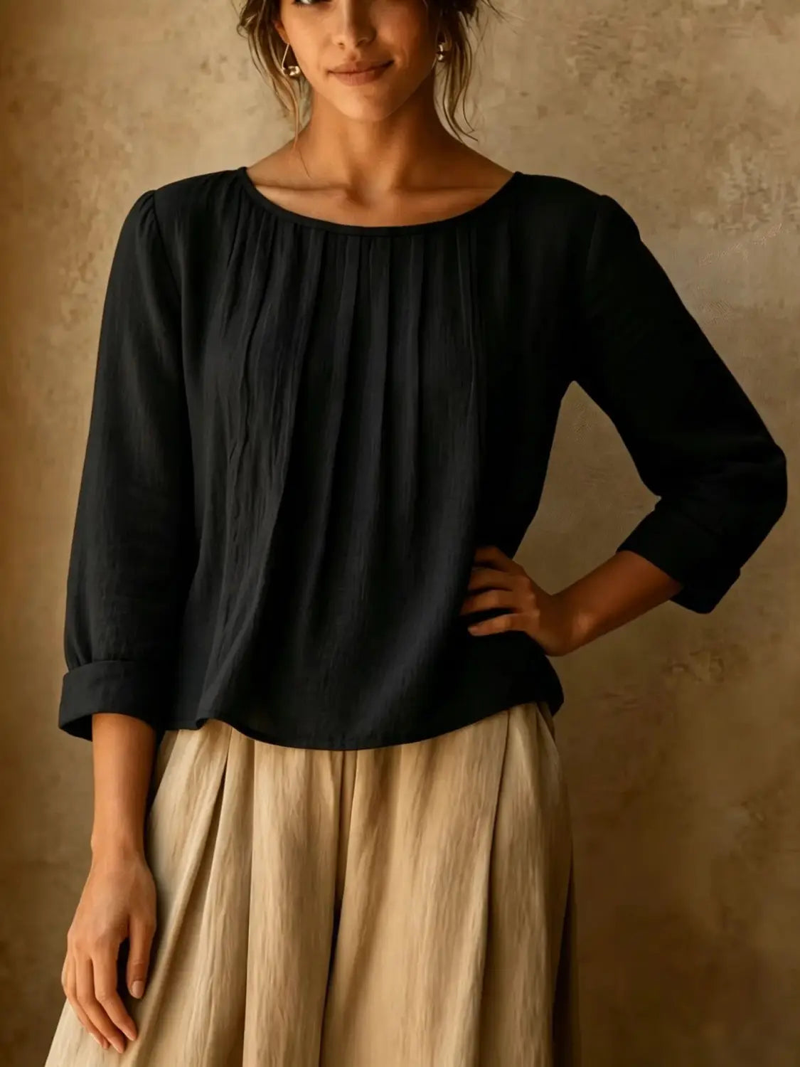 Une blouse ample en lin et coton pour femmes, noire, avec une encolure légèrement bouffante froncée et de doux plis sur l’avant.