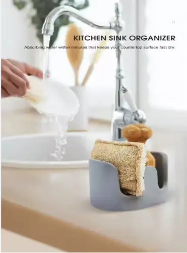 Gray plastic Diatom Mud sponge rack kitchen sink caddy organizer holding a beige sponge and wooden scrubber.