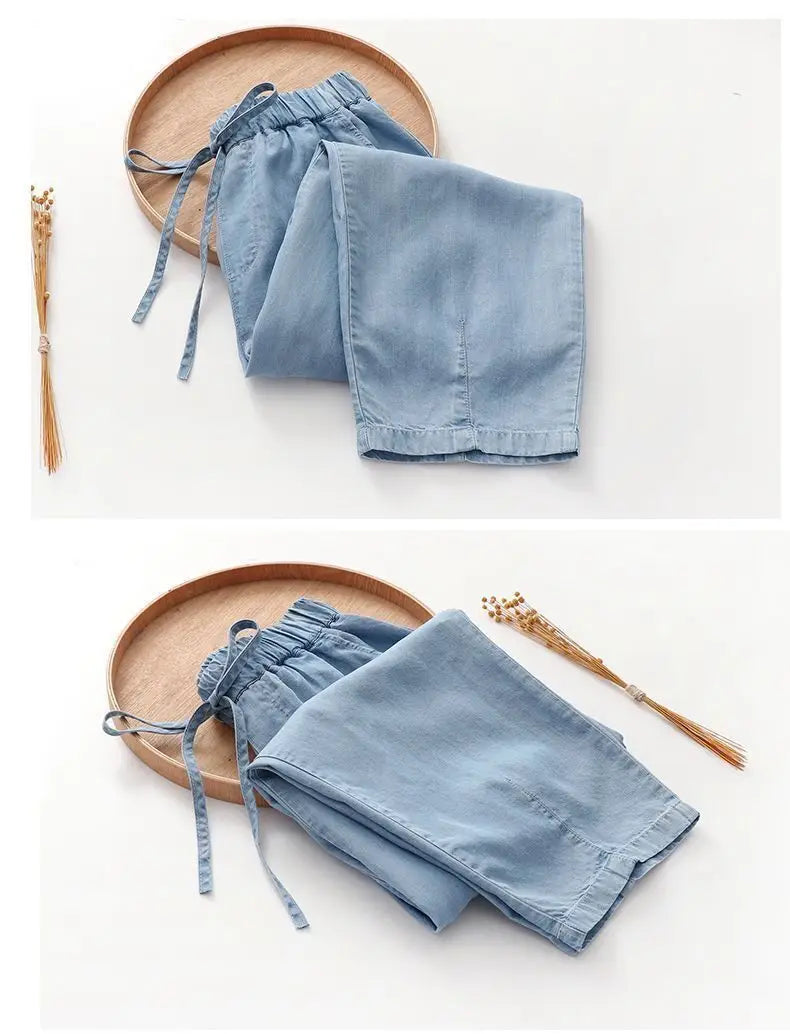 Light blue denim harem jeans high waisted drawstring pants featuring an elastic waistband and drawstring ties.