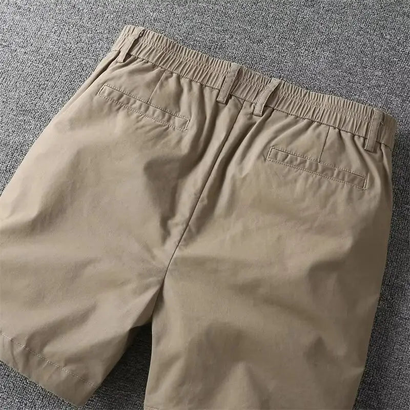 Beige cotton men casual slim fit cargo shorts shown from the back with an elastic waistband and two back pockets.