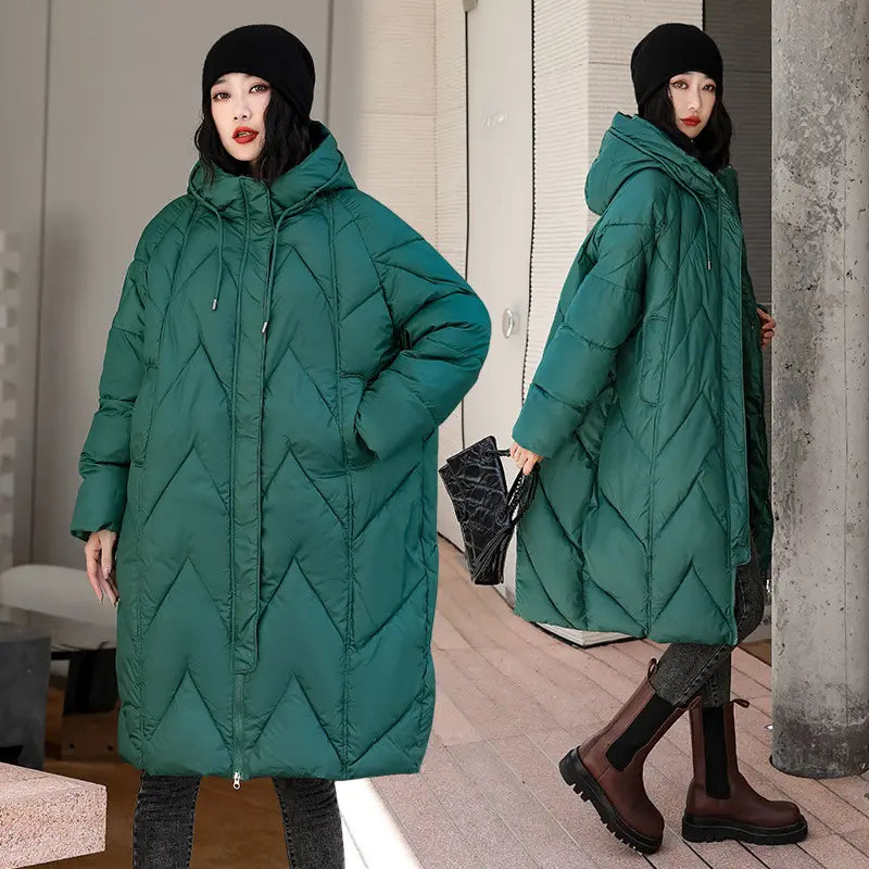 Emerald green quilted mid length padded down jacket for women with a hood and front zipper designed as a winter coat.