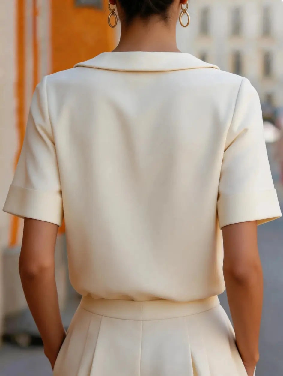 Cream-colored solid color short sleeve versatile top in a tailored fit with a structured collar and short sleeves.