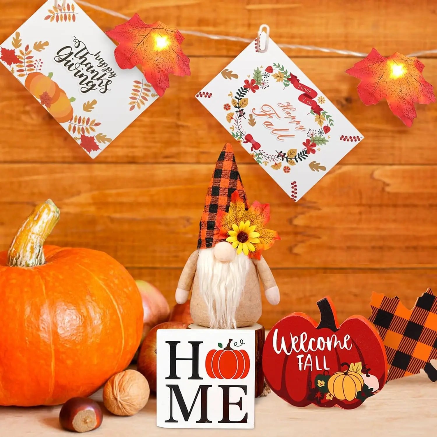 A plush autumn gnome with a black and orange plaid hat adorned with a sunflower featured in the fall tiered tray decor set with gnomes and lights.