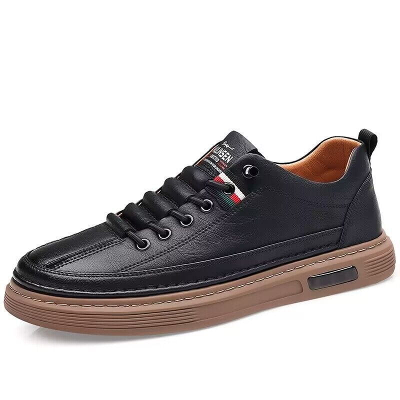 Schwarzer Ledersportschuh im Low-Top-Stil mit gepolstertem Design und brauner Gummisohle mit einem kleinen rechteckigen Logo-Patch an der Seite.