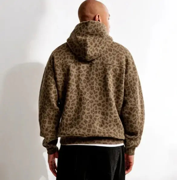 Un sweat-shirt d’hiver oversize vintage pour hommes à imprimé léopard brun, avec une coupe ample et des poignets côtelés.
