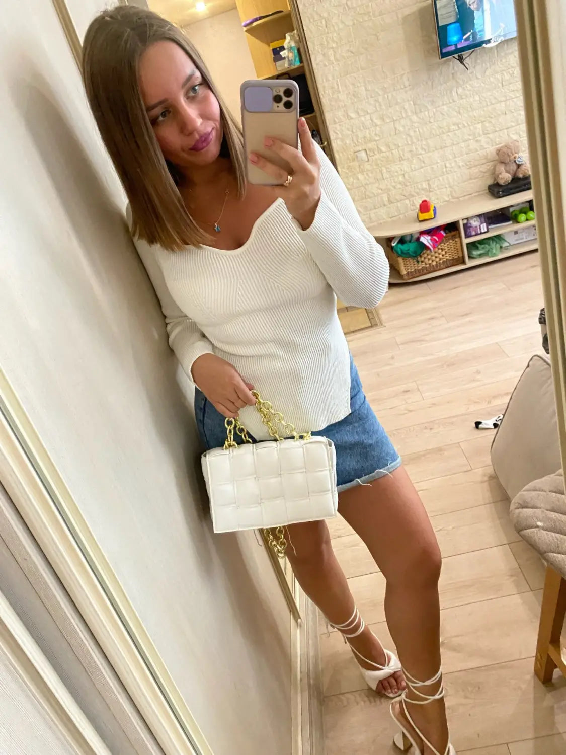 white quilted handbag with gold chain strap paired with ribbed sweetheart neck long sleeve knit pullover in cream color