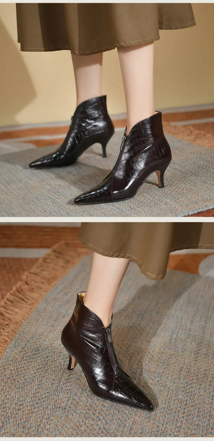 black crocodile-patterned leather ankle boots with a pointed toe and slender stiletto heel shown from the back side
