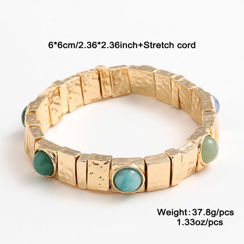 Vintage hammered gold bangle with gold-toned stretch design featuring textured rectangular segments and round turquoise stones set in a repeating pattern.