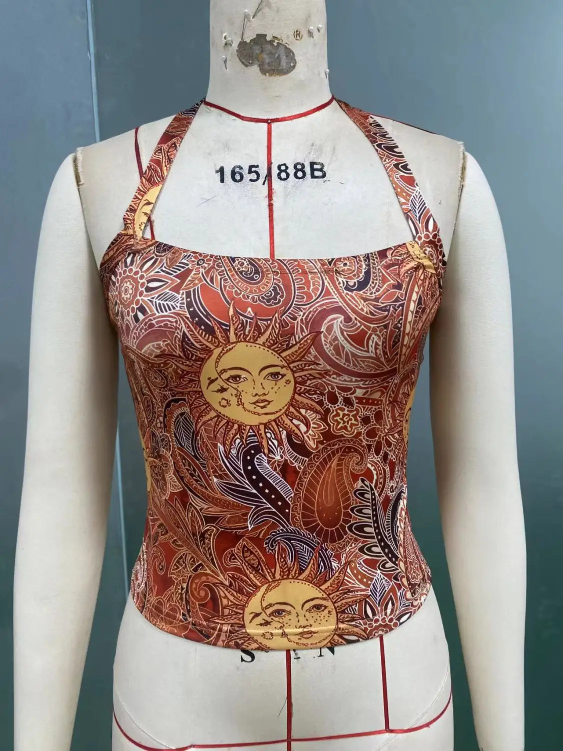 Ein leuchtendes Paisley-Haltertop Slim Fit Sun Print in Rost- und Goldtönen mit aufwendigen Paisley-Designs und stilisierten Sonnenmotiven.
