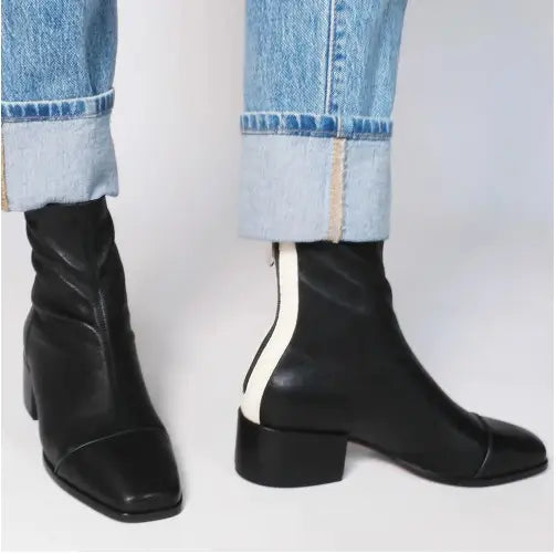 schwarze Stiefeletten aus Leder mit eckiger Zehenpartie, weißem Zierreißverschluss-Streifen entlang der Rückseite sowie einem Blockabsatz, von der Rückseite dargestellt