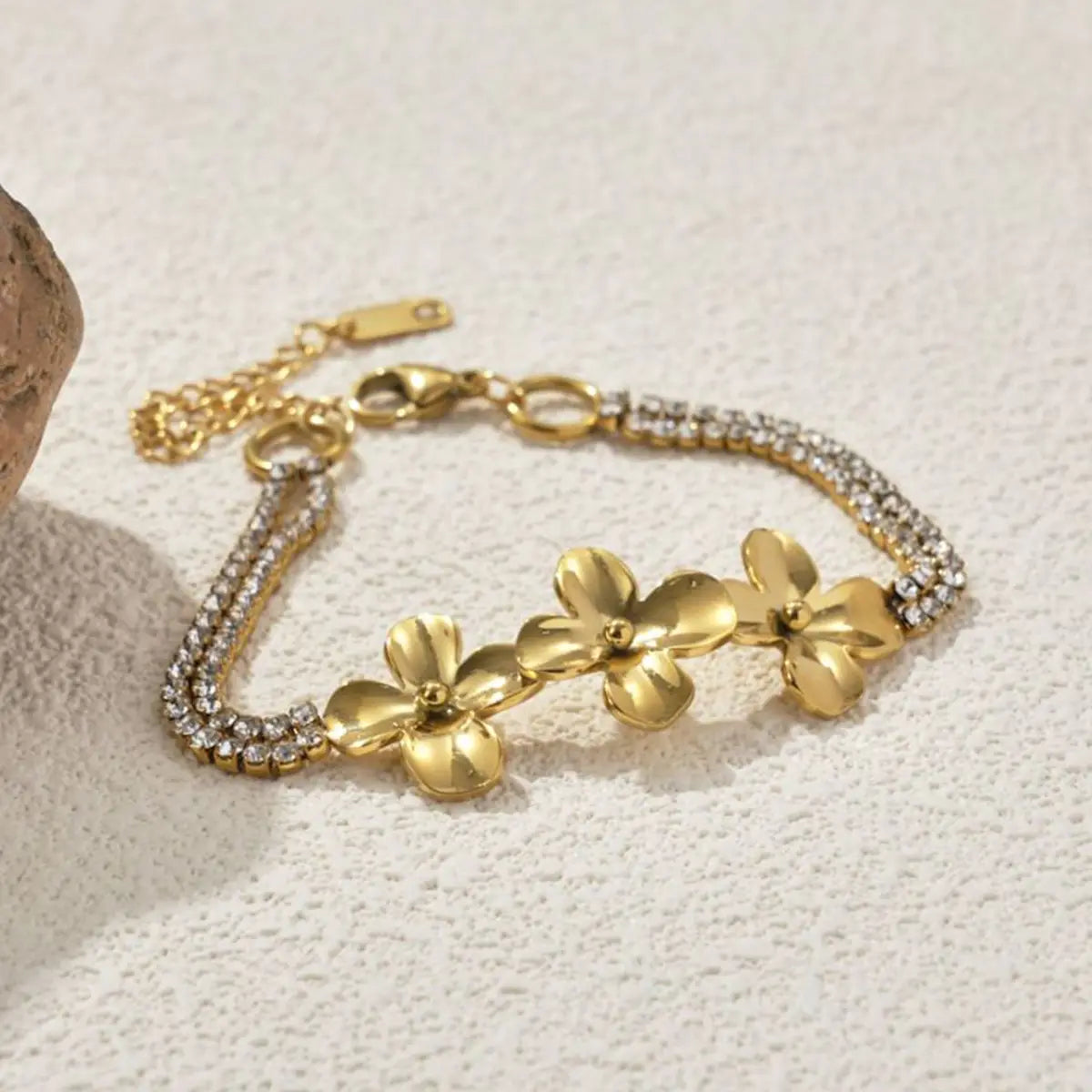 18k gold plated crystal flower double strand bracelet featuring a gold-toned design with three prominent flower charms and a sparkling chain adorned with clear crystals.