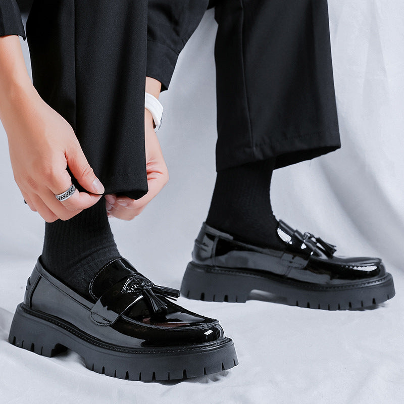 Men’s black patent leather tassel platform shoes with thick textured rubber sole and decorative front tassels