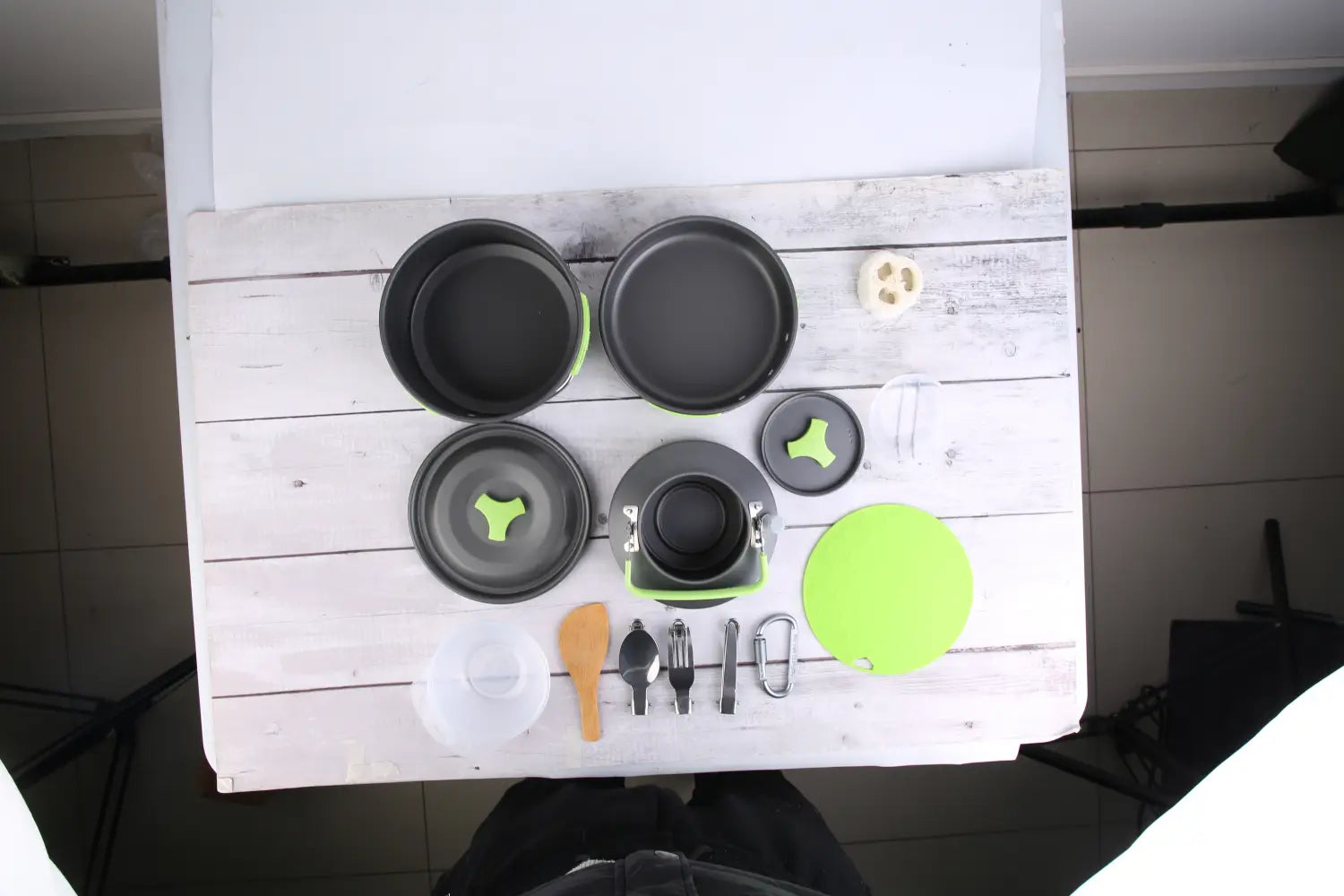 Black and lime green collapsible camping cookware set including pot pan kettle with matching lid spoon fork knife and carabiner designed for outdoor use