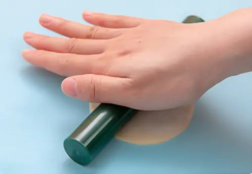 dark green cylindrical roller with a smooth glossy finish made of durable material resting on a light wooden base for dumpling maker 3 in 1 manual dough pressing tool.