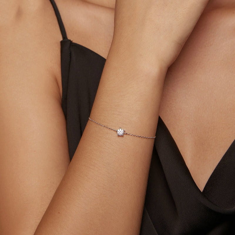 A delicate rose gold moissanite silver chain bracelet featuring a single sparkling solitaire diamond on an elegant chain.