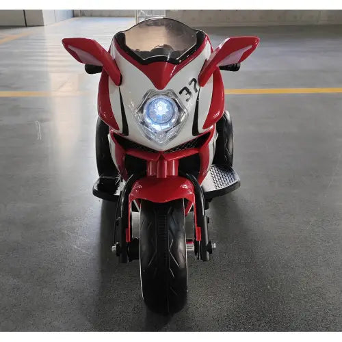Red and white 6v kids electric ride on motorcycle featuring a glowing blue headlight designed for children.