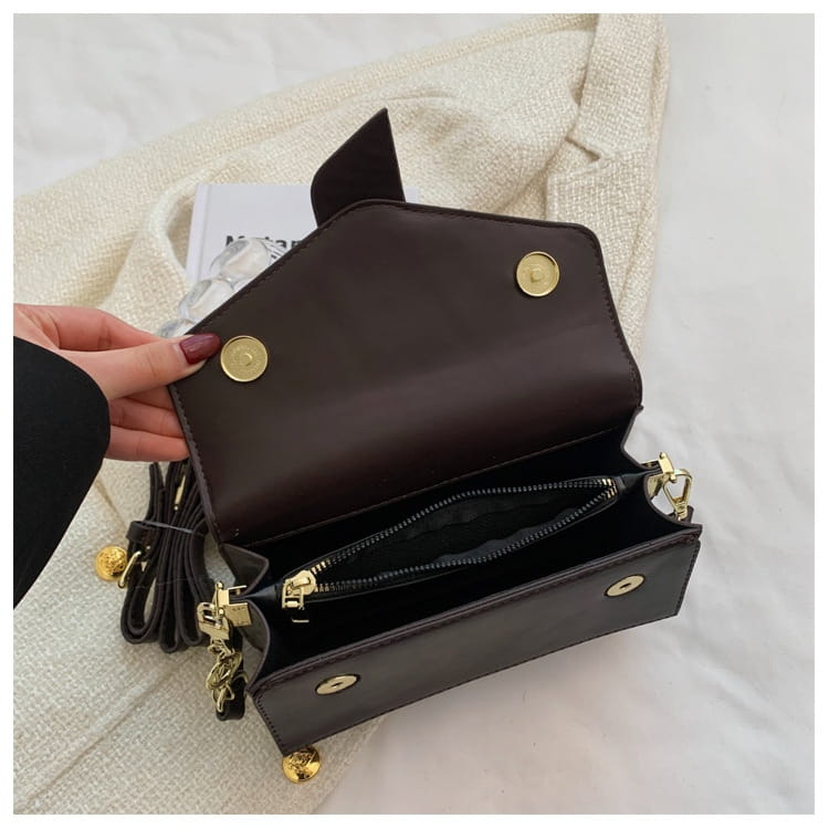 Dark brown leather monogram letter print crossbody messenger bag with gold-tone hardware and tassel strap.