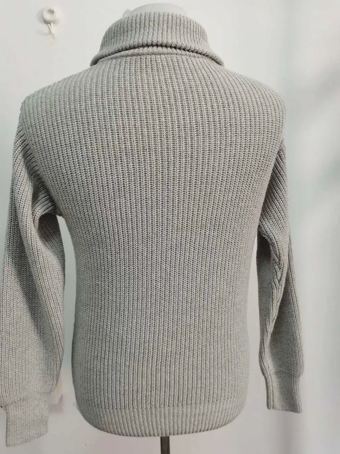 Grauer Herren-Halbrollkragen-Rippstrickpullover mit einem strukturierten Waffelmuster und Kabelstrick-Details an den Ärmeln.