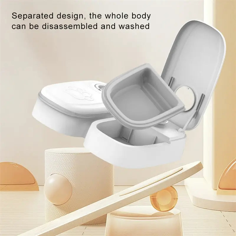 White and gray plastic automatic pet feeder with a separated design for easy cleaning and gravity waterer and food dispenser functionality.