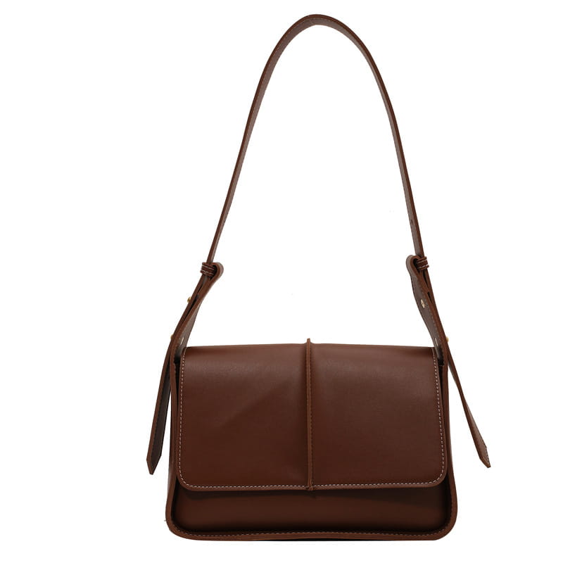 Brown leather crossbody bag with a sleek minimalist design and matching strap for shoulder use.