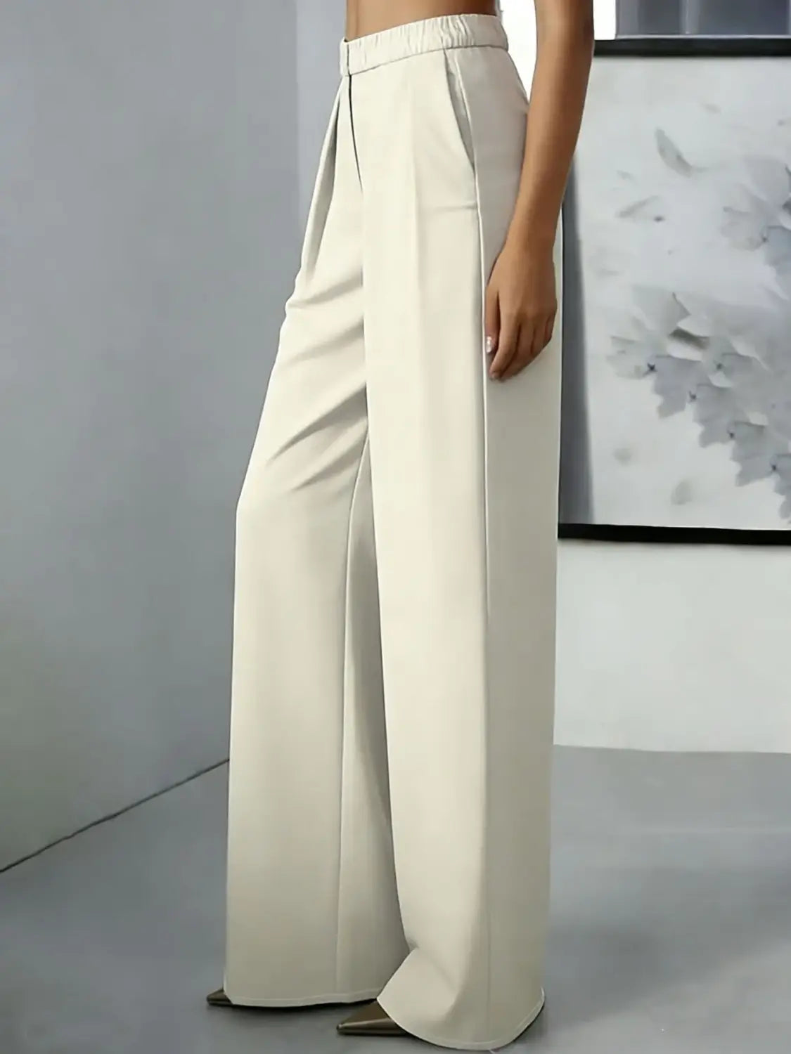 Pantalons à jambes larges couleur crème avec une ceinture élastique à taille haute et une coupe droite nette et épurée.