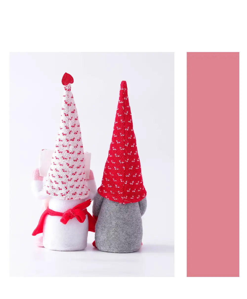 Zwei festliche Filz-Valentinstag-Gnom-Plüsch, Rudolph-Puppe-Deko-Ornamente: eines in Weiß mit einer rot gemusterten Mütze und einem rosa Schal, das andere in Grau mit einer einfarbig roten Mütze.