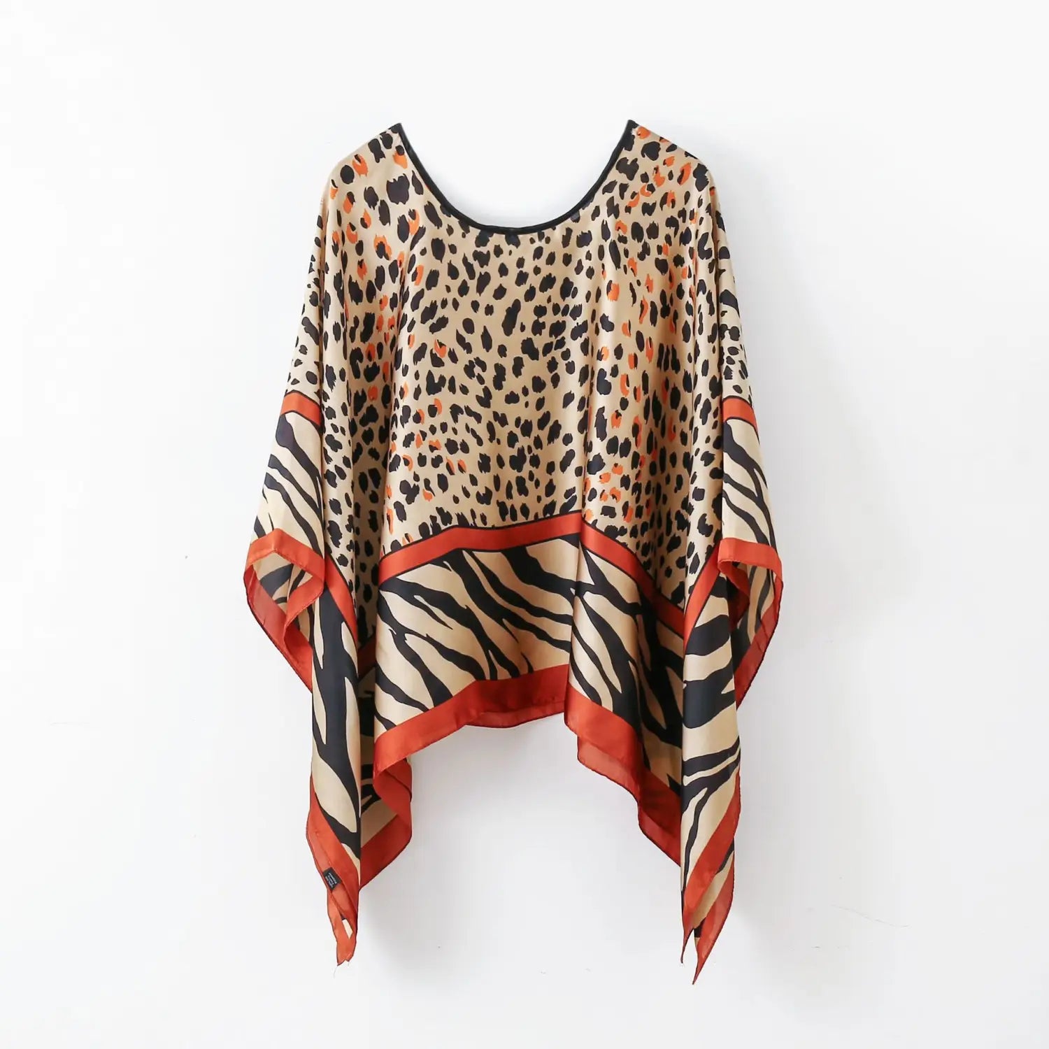 printed silk patterned pullover shawl cape outerwear featuring a lightweight flowing design with a bold leopard print top section and zebra stripes below accented by vibrant orange trim along the edges.
