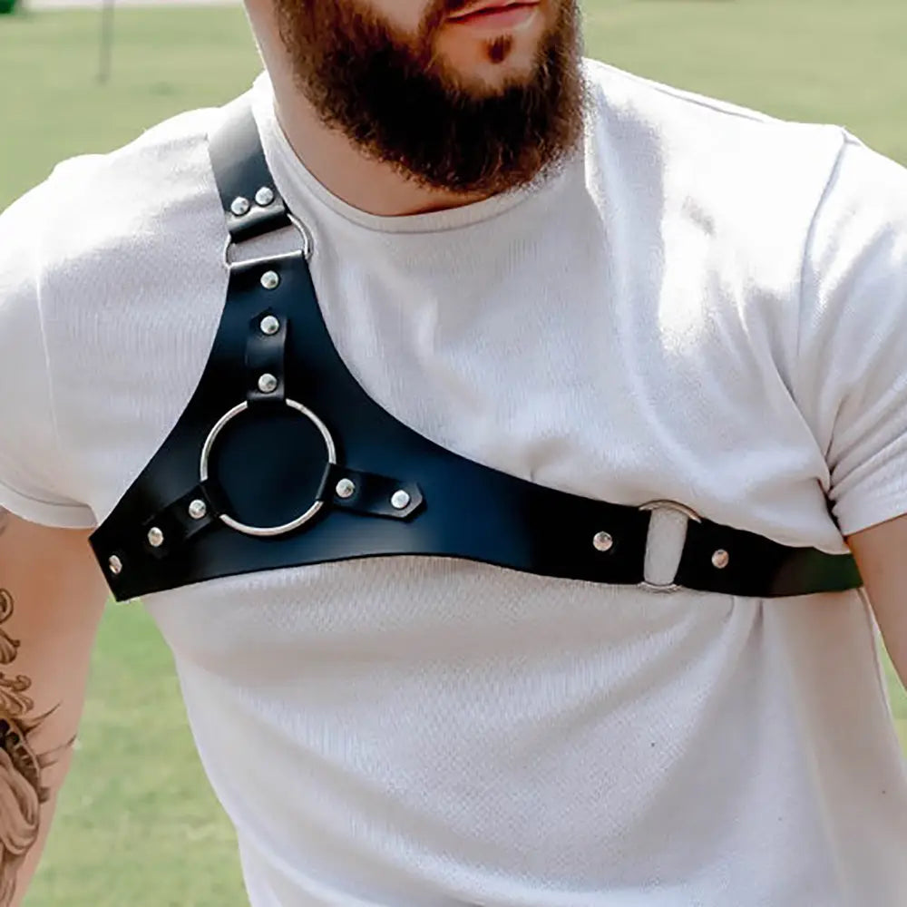 Black leather studded dance harness with silver-toned metal buckles and a central circular ring.