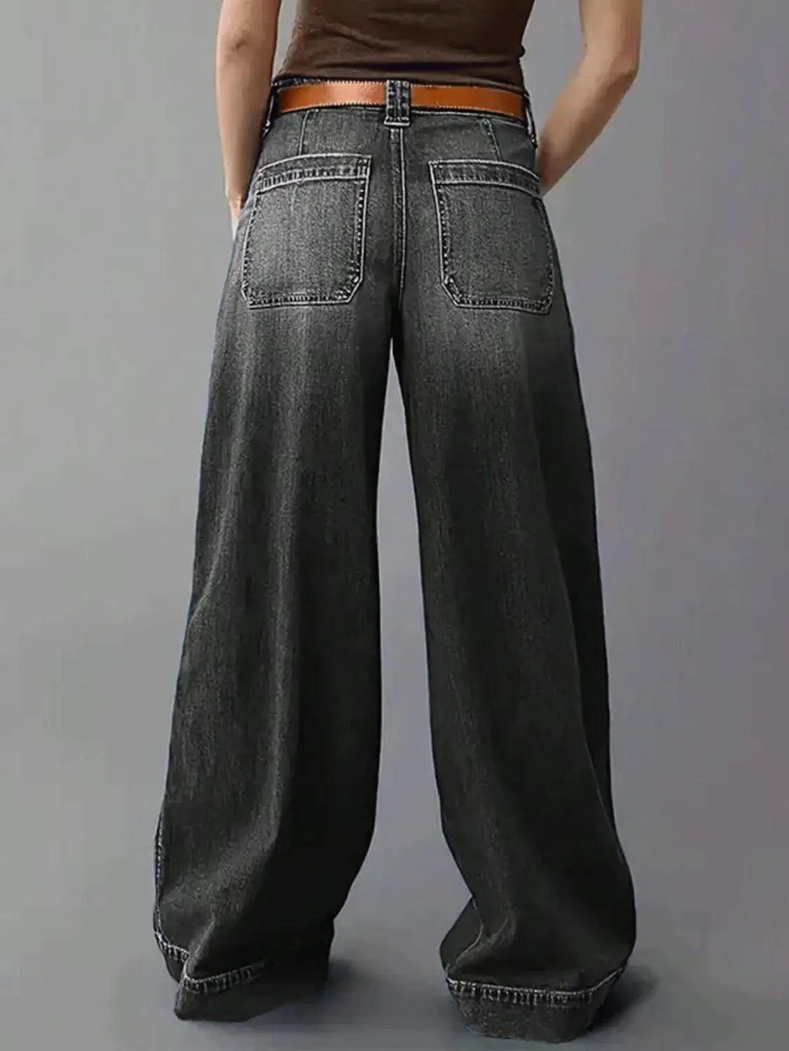 Dark gray wide leg denim pants with a brown leather belt displayed from the front.