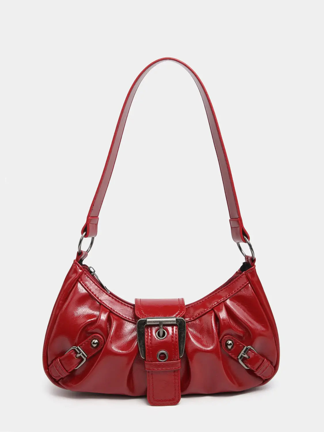 A vintage leather shoulder bag in glossy red patent leather with a curved silhouette and silver-toned metal buckle details.