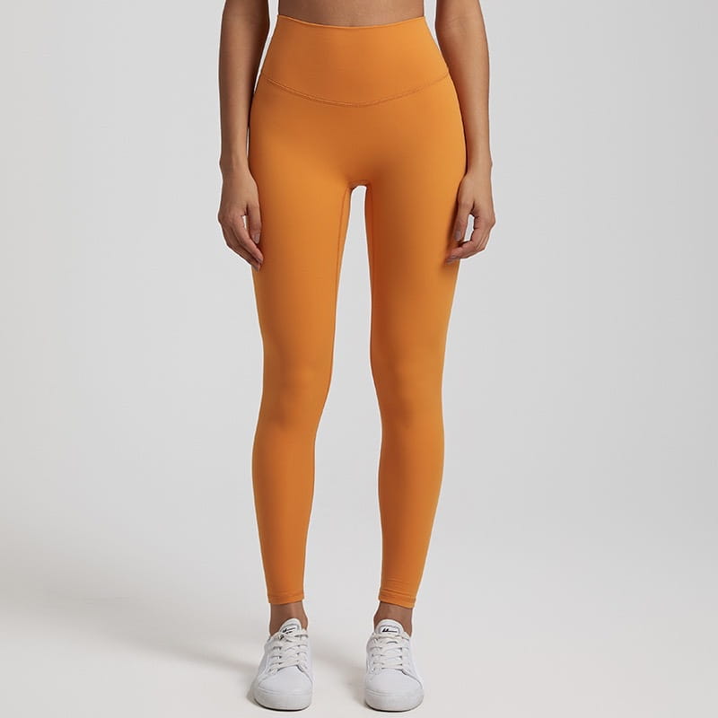 A pair of high waisted stretch fitted leggings in bright orange made from stretchy fabric for a comfortable fit.