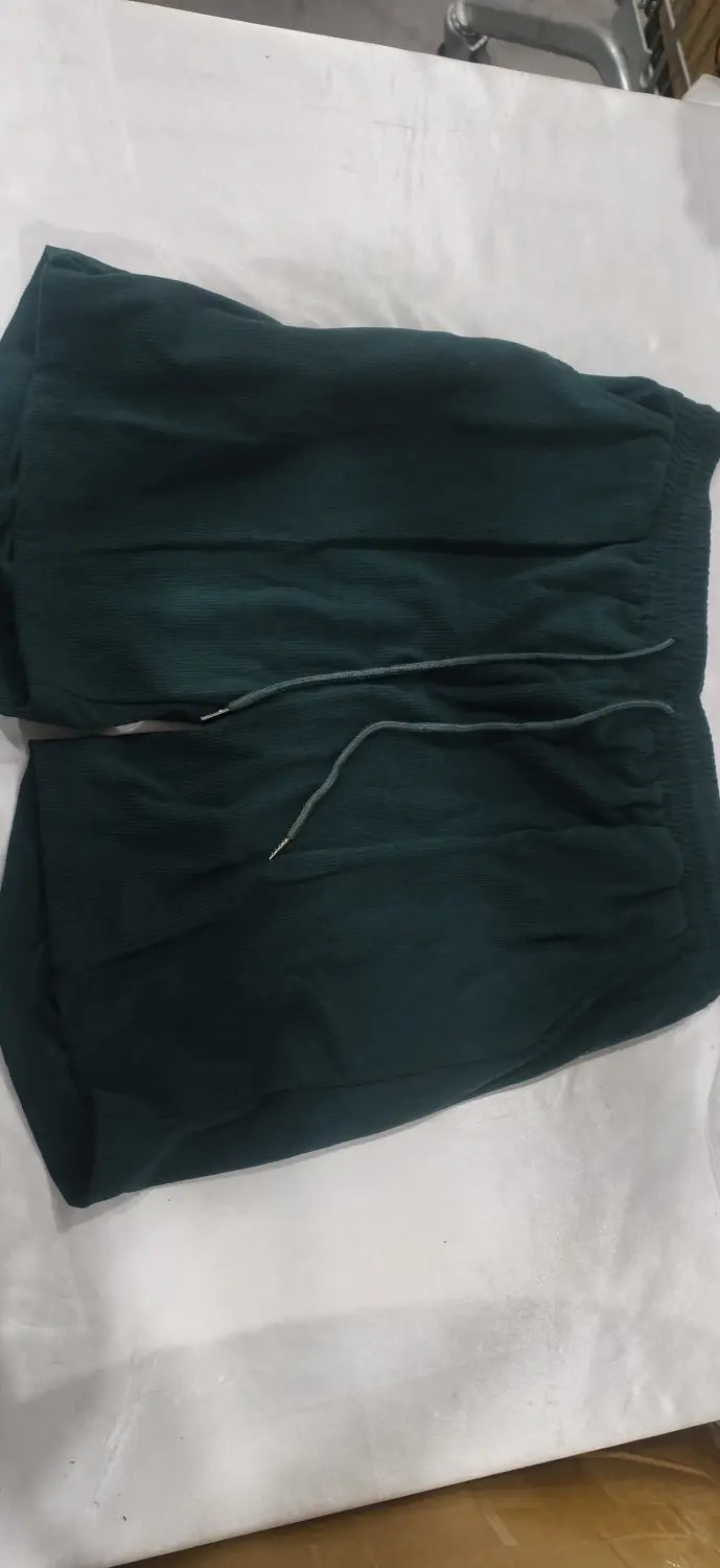 Dark green corduroy athletic shorts with a drawstring waistband as part of a men corduroy short sleeve polo shorts set.