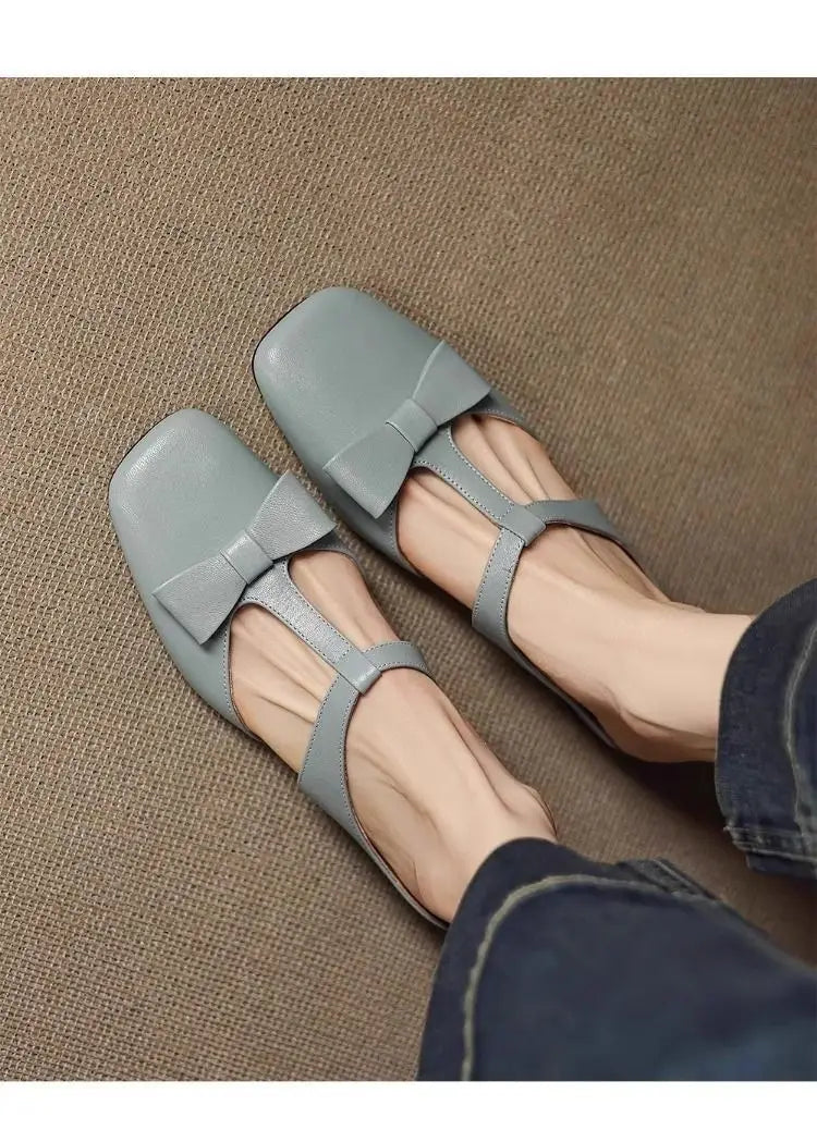 Light gray leather bow closed toe square-toe flats for women with a bow detail on the front.