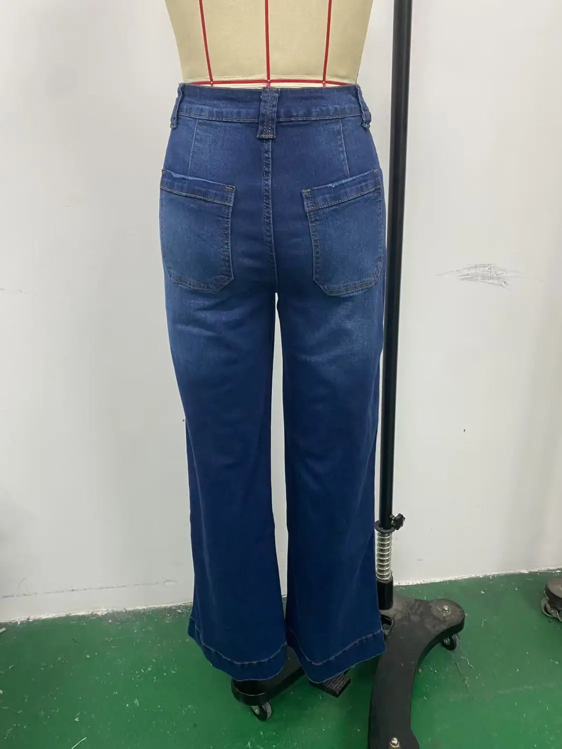 blue denim high-waisted wide-leg pants with belt and back pockets shown from the back side