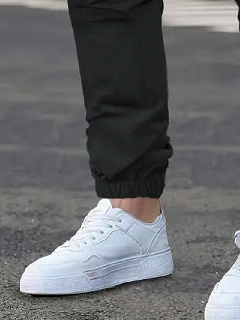 men’s slim fit cropped cargo joggers with drawstring waist paired with white low-top sneakers featuring a clean minimalist design and textured rubber soles