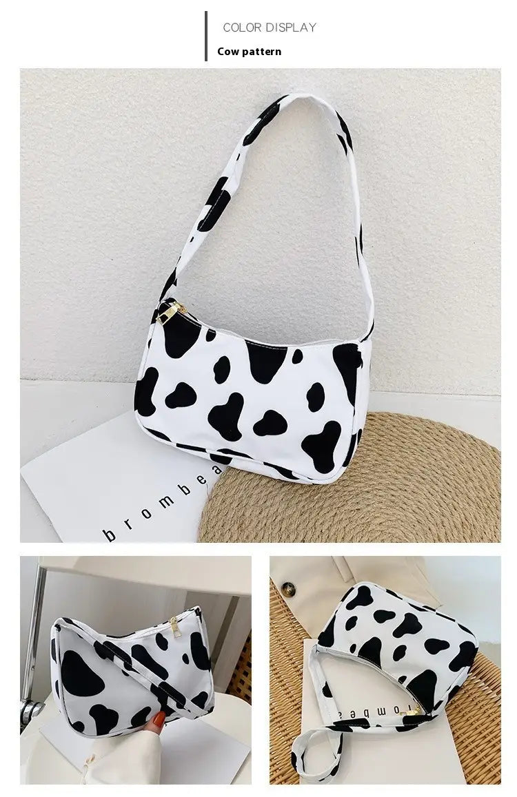 Sac bandoulière blanc à motif d’imprimé vache noire, en nylon, présenté comme un sac sous-bras à imprimé léopard et à carreaux.