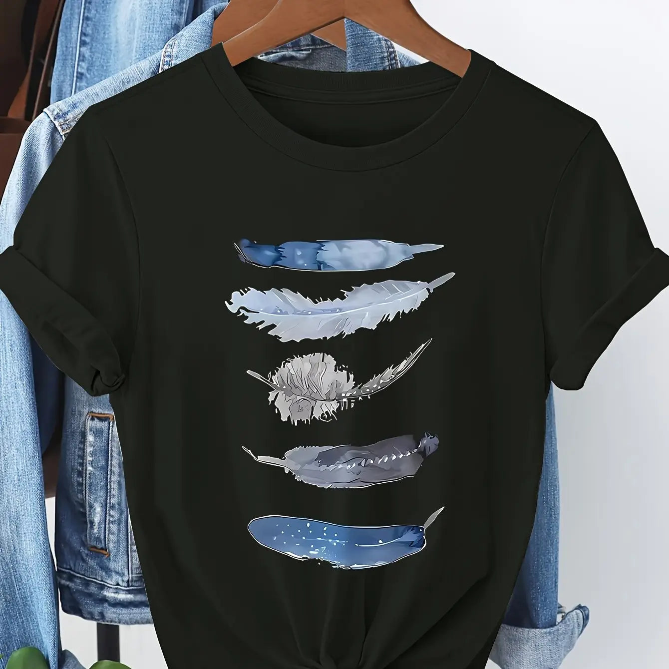 Schwarzes kurzärmeliges Damen-Baumwoll-T-Shirt mit einer vertikalen Anordnung von fünf Wasserfarben-ähnlichen Federn in den Tönen Blauweiß und Grau.