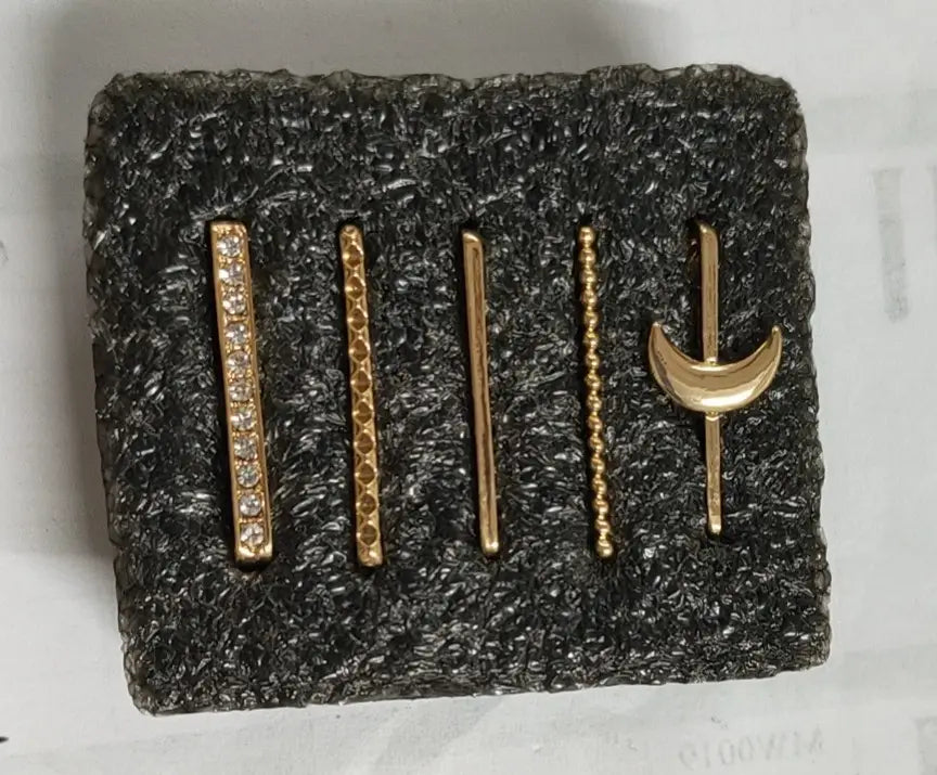 Set of five gold-toned bar-style earrings with silicone strap decorative ring featuring clear stones and crescent moon design.