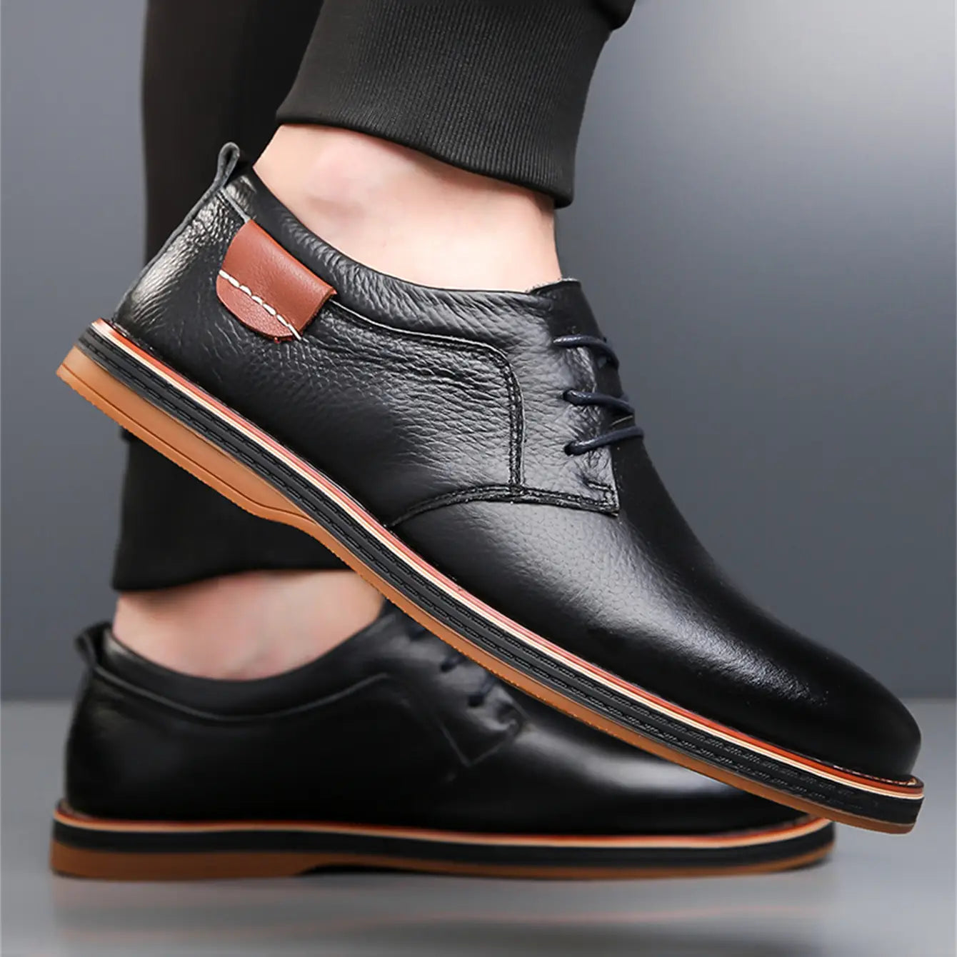 men’s handmade genuine leather lace up oxford shoes in black leather with tan accents on the sole and a matching patch at the heel shown from the back side