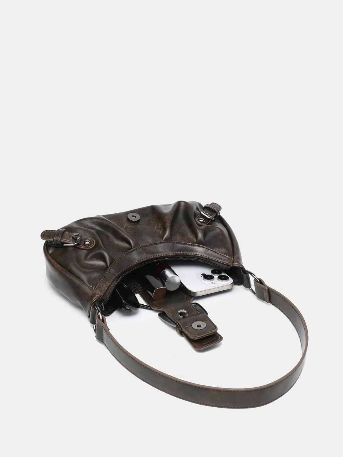 Dark brown leather crossbody bag with a slightly distressed finish and adjustable strap featuring buckle details for vintage shoulder style.