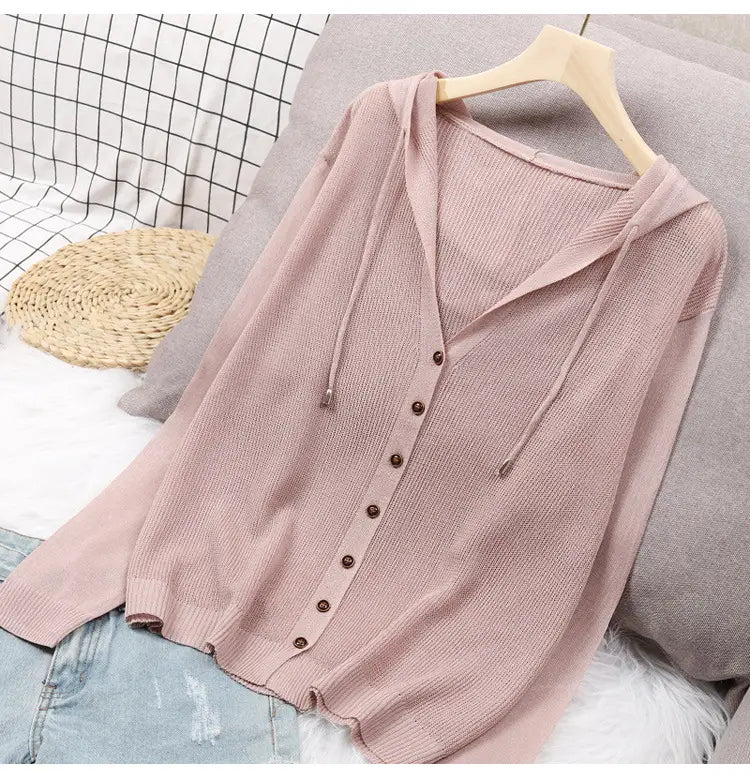 Ein weichrosa geripptes Strick-Hoodie-Cardigan mit dunkelbraunen Knöpfen und Kordelzügen, ausgelegt für einen angenehmen Lagen-Look.