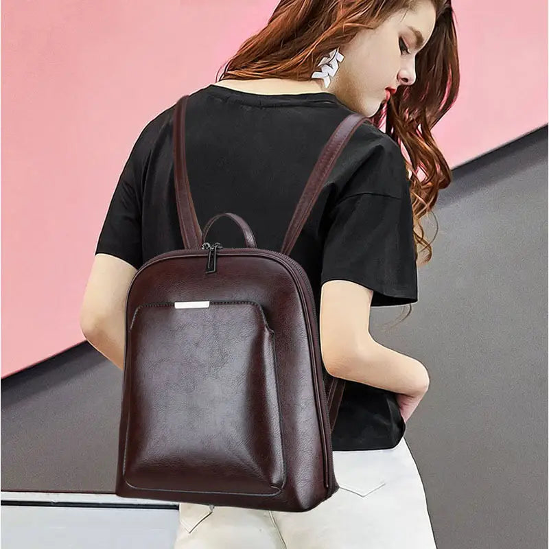 brown leather pu leather anti-theft backpack with a sleek minimalist design and subtle stitching details featuring a magazine print