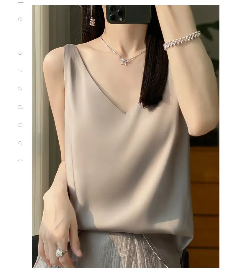 A soft light beige silky satin sleeveless camisole top with a deep v-neckline.