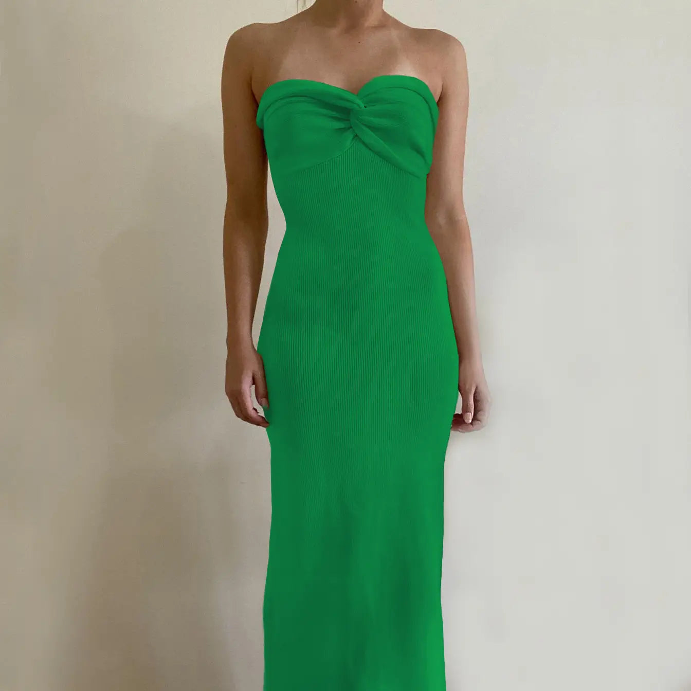 A vibrant green off shoulder knotted ribbed knit midi dress featuring a strapless fitted bodice and a prominent bow detail at the neckline.