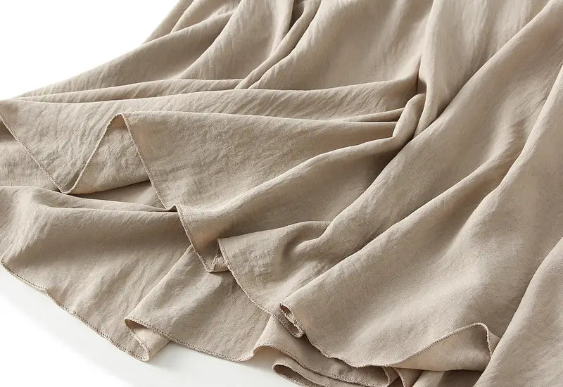 beige linen pleated wide flare maxi skirt with a soft slightly textured surface and natural folds