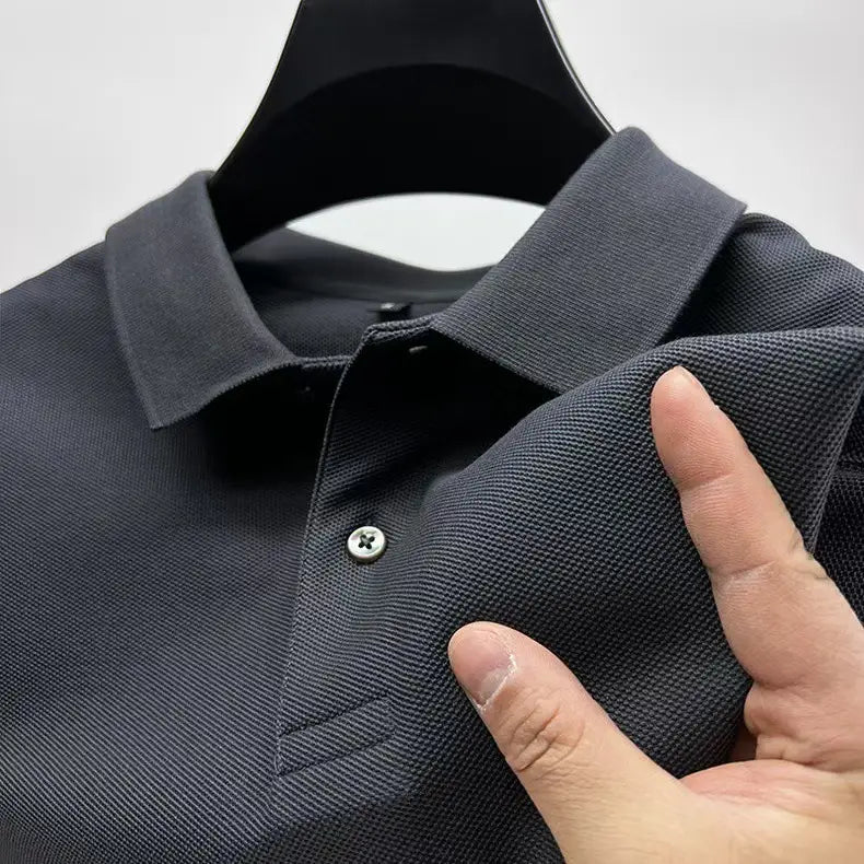Dunkelgraues Strickpolohemd mit Textur, klassischem Kragen und silberfarbenem Knopf aus Baumwolle für den Freizeitgebrauch.