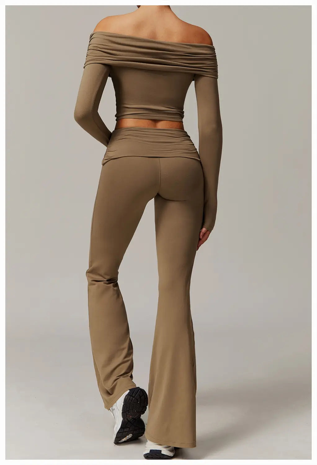 conjunto de top corto estilo hombro descubierto color verde oliva a juego y pantalones de yoga acampanados de cintura alta, confeccionados en tejido elástico con diseño fruncido.