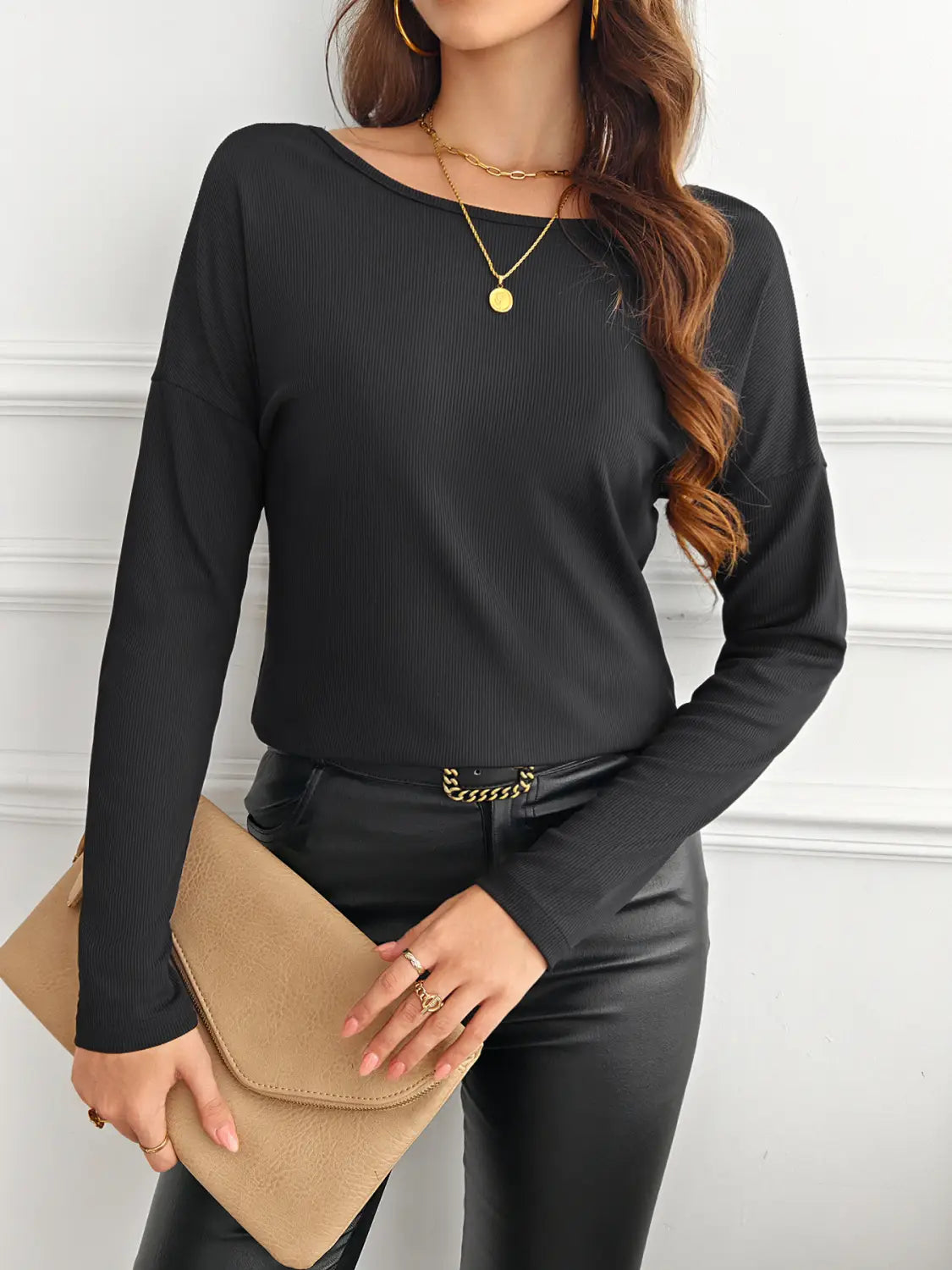 Black ribbed long-sleeve top with a rounded neckline featuring a butterfly lace back detail.