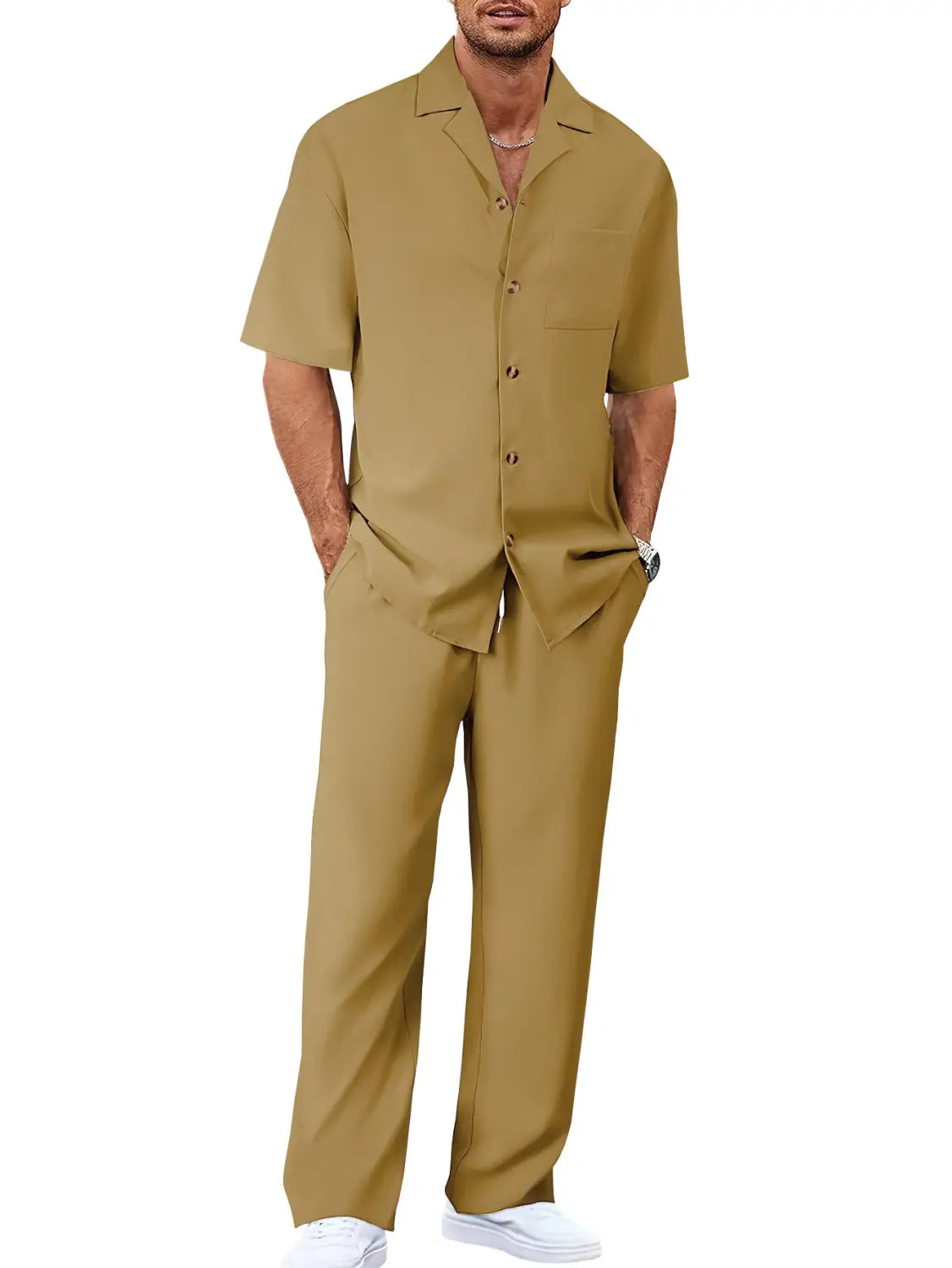 A man wearing a khaki-colored short sleeve casual suit set with a relaxed fit button-up shirt and matching trousers.